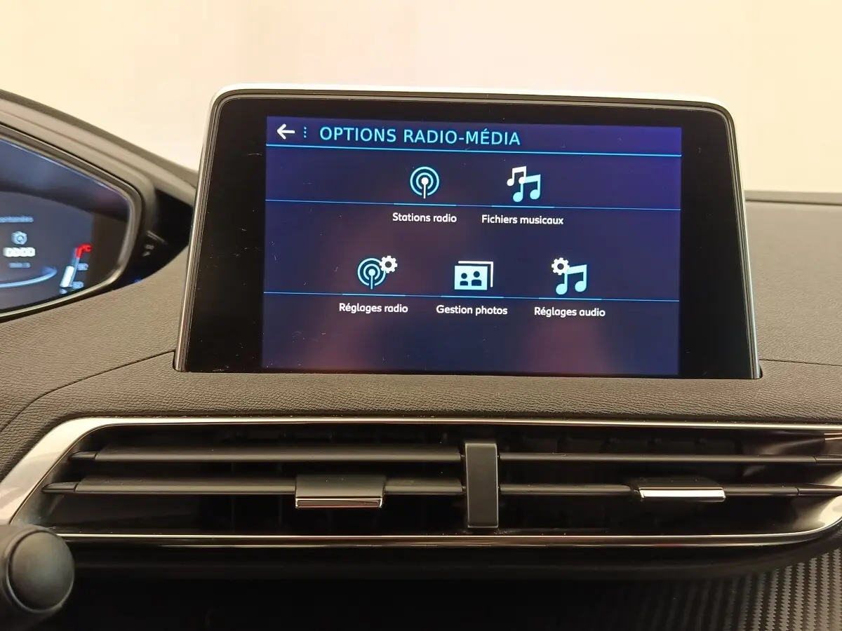 Écran tactile central affichant les options radio-média dans l’habitacle du Peugeot 5008 gris foncé, vue de face.
