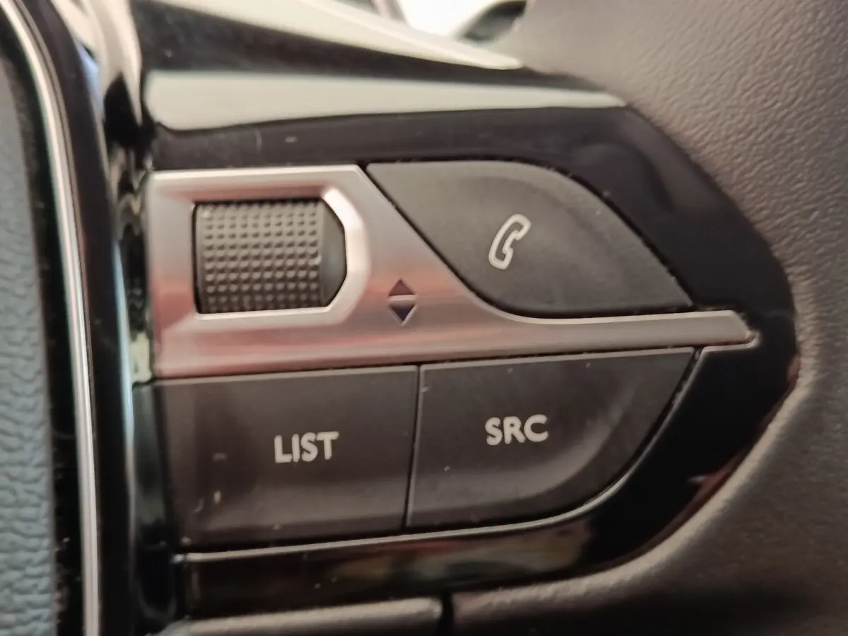 Gros plan sur les commandes multifonctions noires et argentées du volant du Peugeot 5008 gris foncé, version 2020.