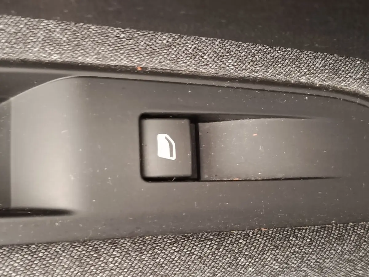 Gros plan sur le bouton de verrouillage des portes dans l'habitacle du Peugeot 5008 gris foncé.