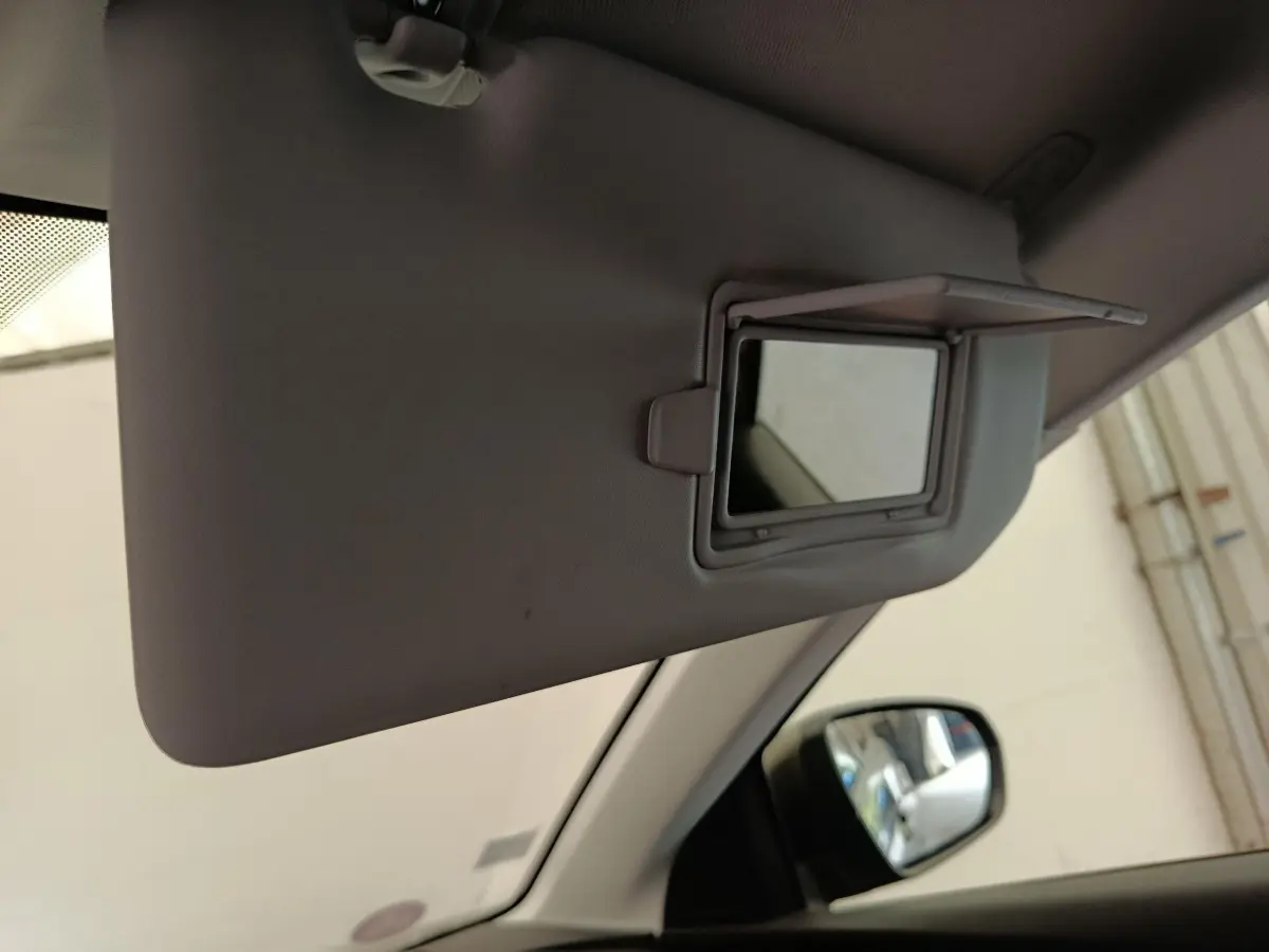 Miroir de courtoisie ouvert sur pare-soleil intérieur gris clair du Peugeot 5008, vue côté conducteur avec rétroviseur extérieur visible.