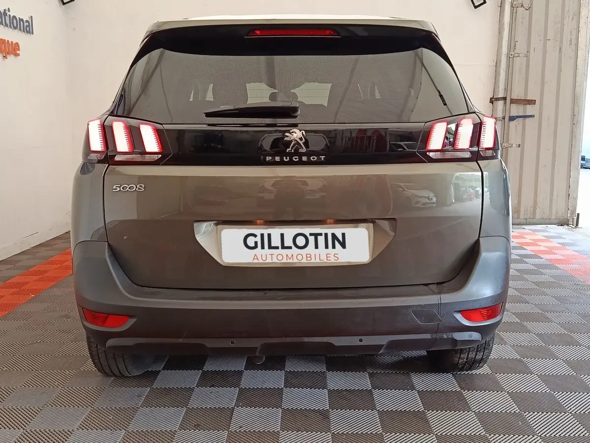Vue arrière d'un Peugeot 5008 gris foncé avec feux LED distinctifs et logo au centre du hayon.