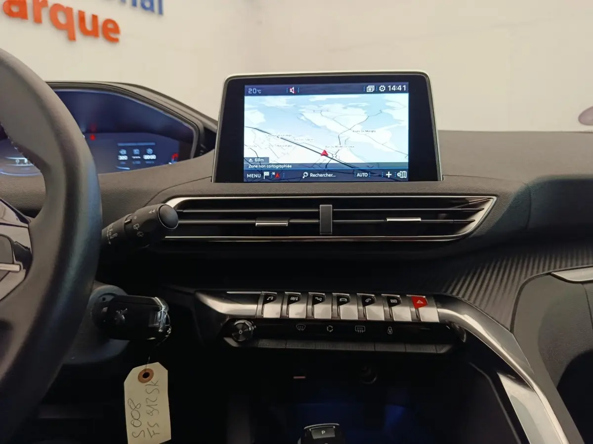 Vue intérieure du tableau de bord du Peugeot 5008 gris foncé 2020, avec écran tactile de navigation central et commandes piano.