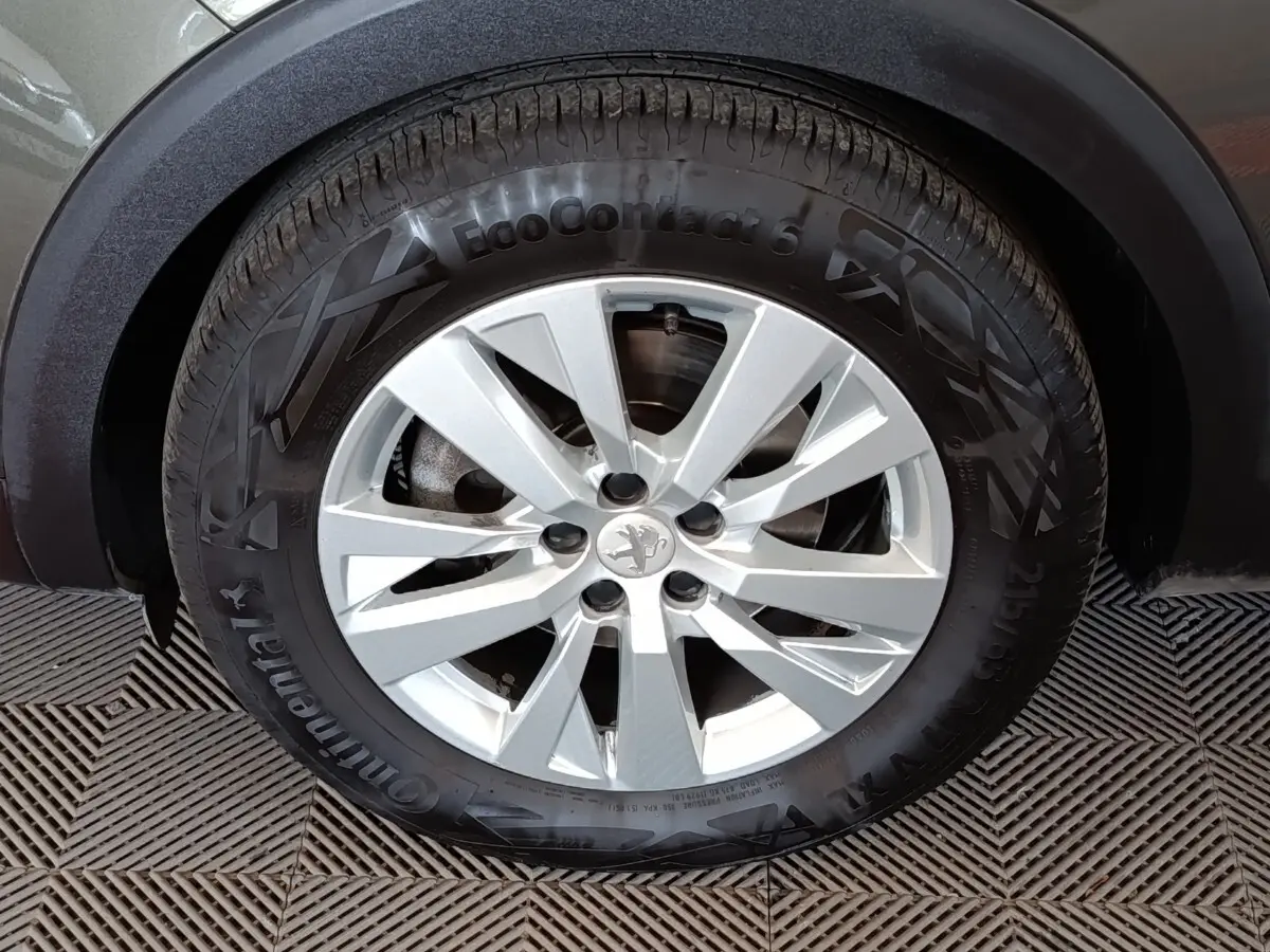 Gros plan sur la roue avant droite du Peugeot 5008 gris foncé, avec jante alliage et pneu Continental EcoContact 6.