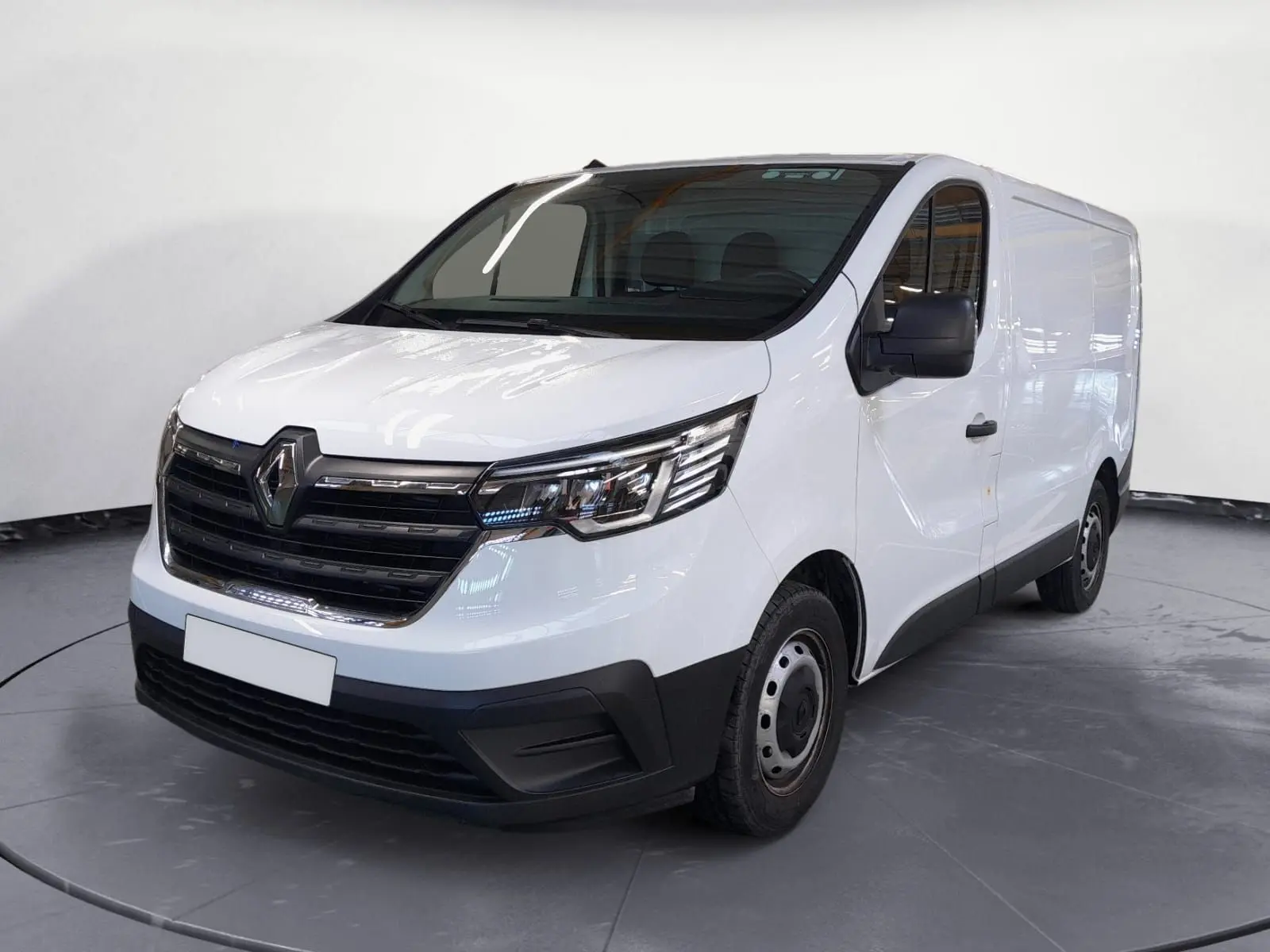 Renault Trafic Fourgon blanc minéral en 3/4 avant droit, avec calandre noire et jantes acier simples.