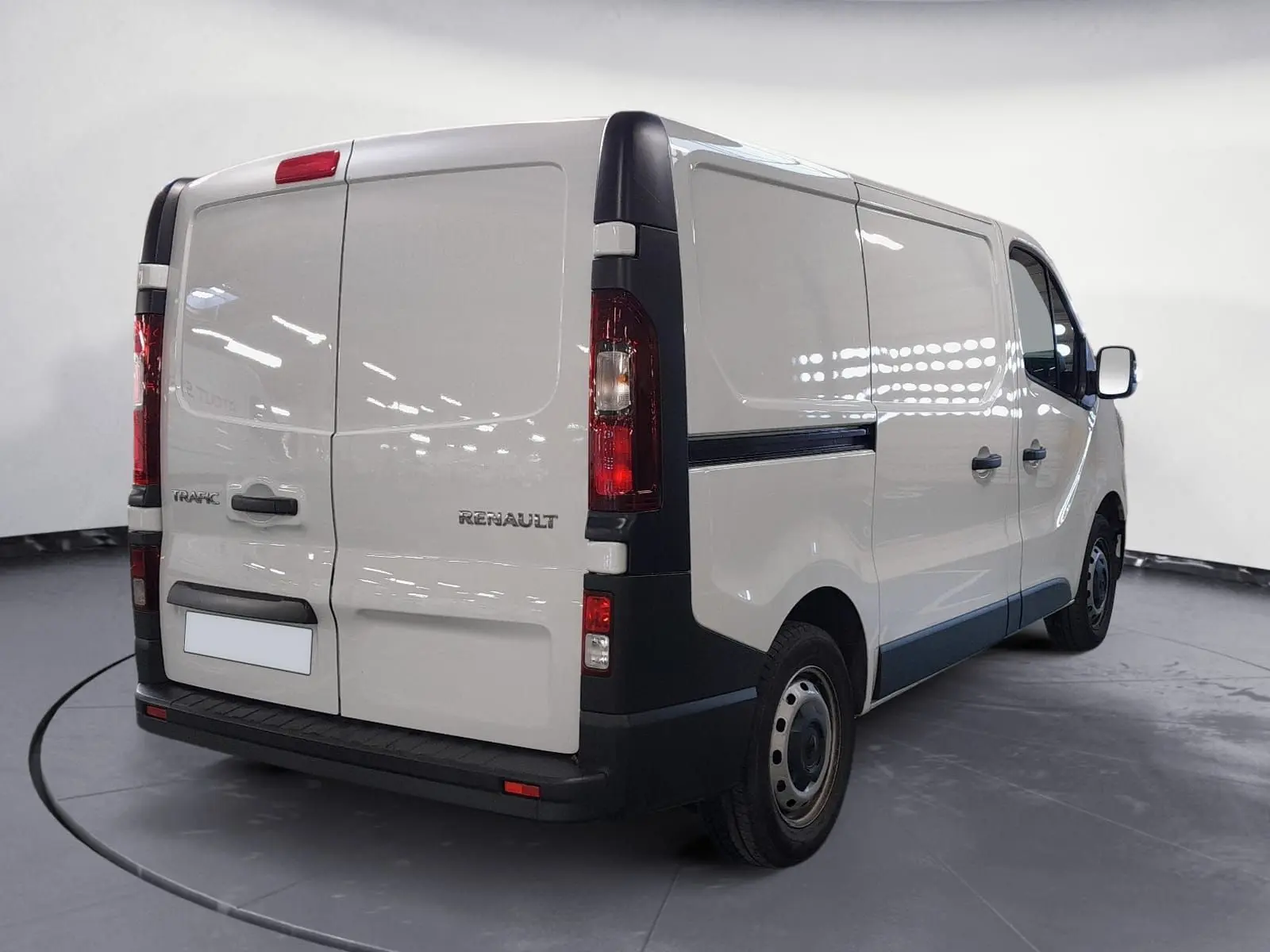Renault Trafic Fourgon blanc minéral vu en 3/4 arrière droit, avec portes arrière fermées et jantes acier noires.