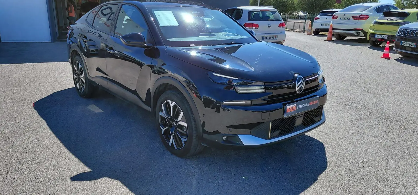 Vue 3/4 avant droite d'une Citroën C4 X noire 2025 avec jantes alliage 17 pouces et toit ouvrant panoramique.
