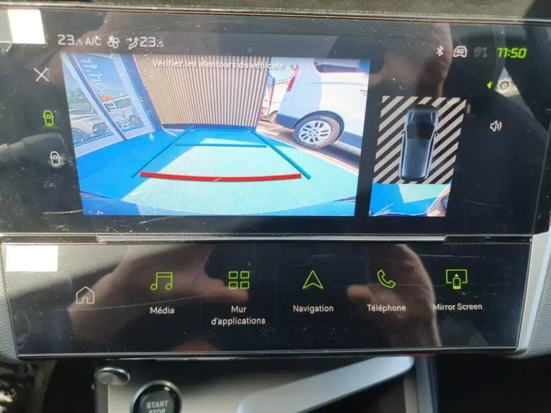 Écran tactile de la Peugeot 308 Hybrid blanc montrant la caméra de recul et l'affichage 360° en stationnement.