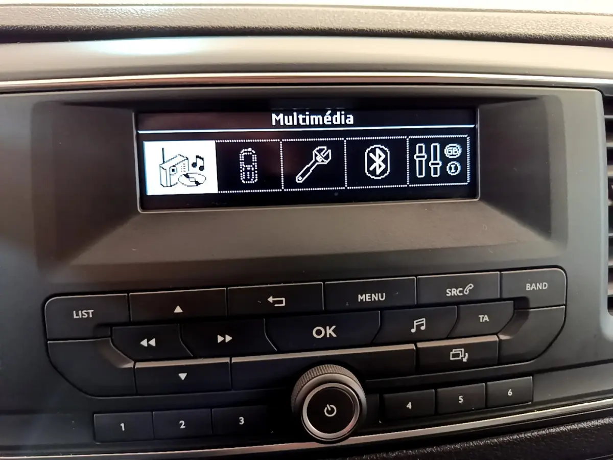 Vue rapprochée de l'écran multimédia et des commandes noires du tableau de bord du Toyota Proace Verso gris clair.