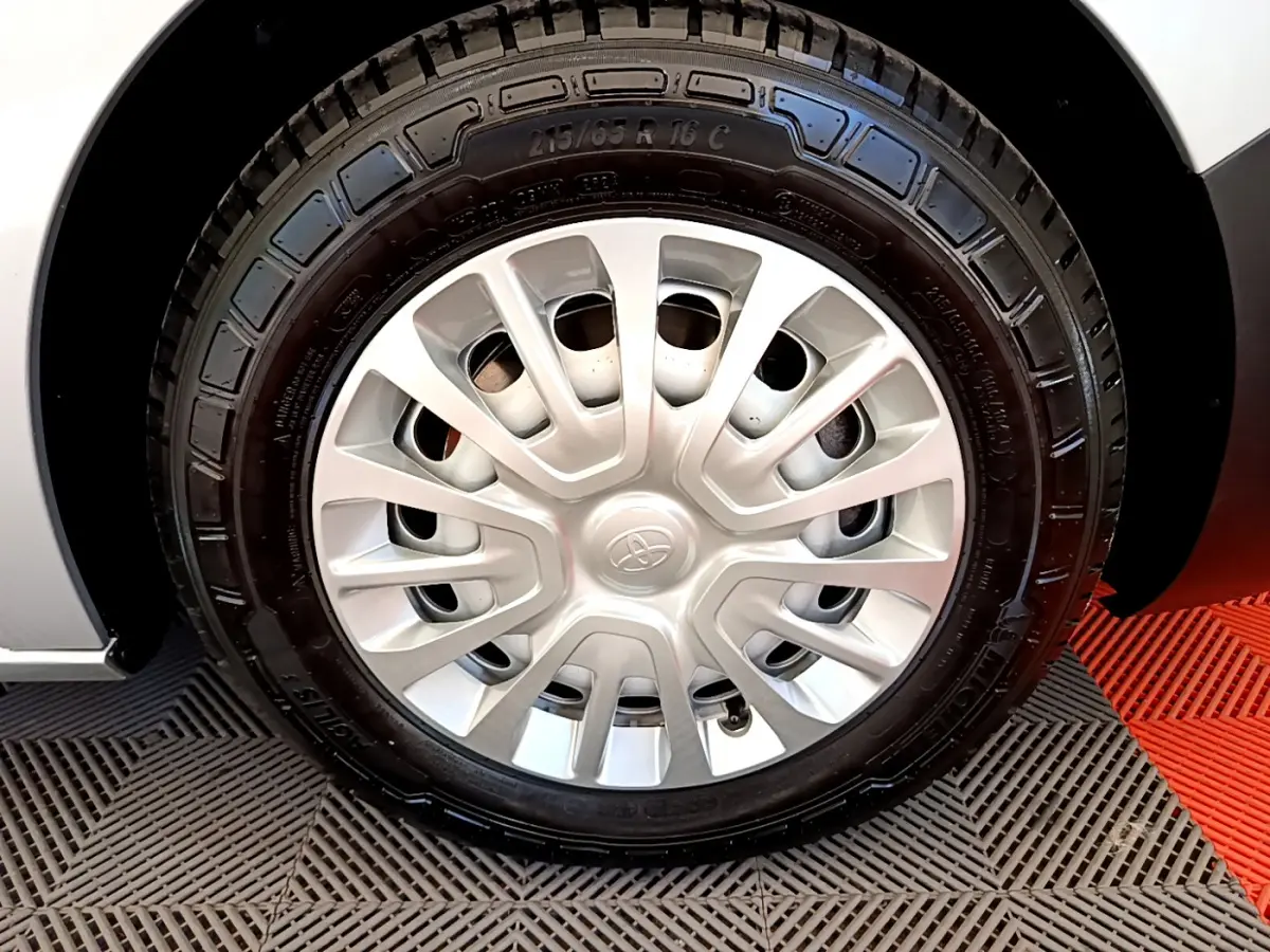 Gros plan sur la roue avant droite du Toyota Proace Verso gris clair, avec jante acier et enjoliveur d'origine.