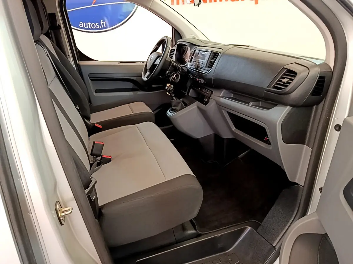 Intérieur avant du Toyota Proace Verso gris clair, vue côté conducteur avec tableau de bord et sièges tissu bicolore.