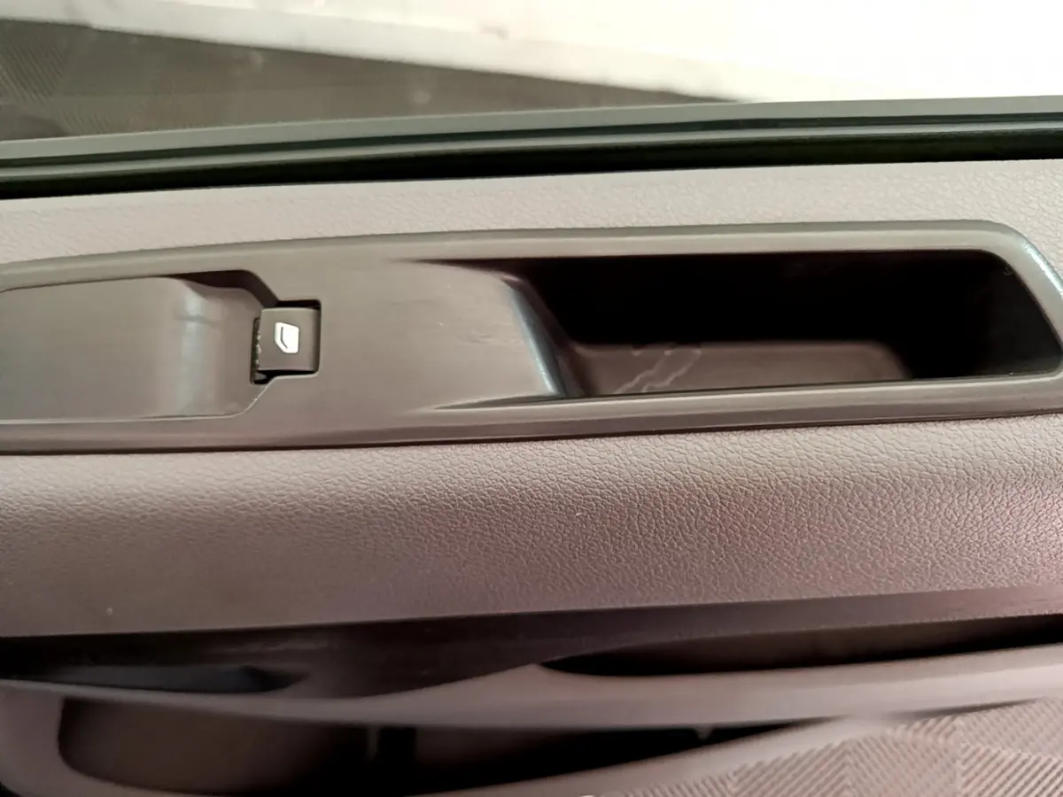 Gros plan sur la poignée intérieure de porte avant droite du Toyota Proace Verso gris clair, avec bouton de verrouillage.