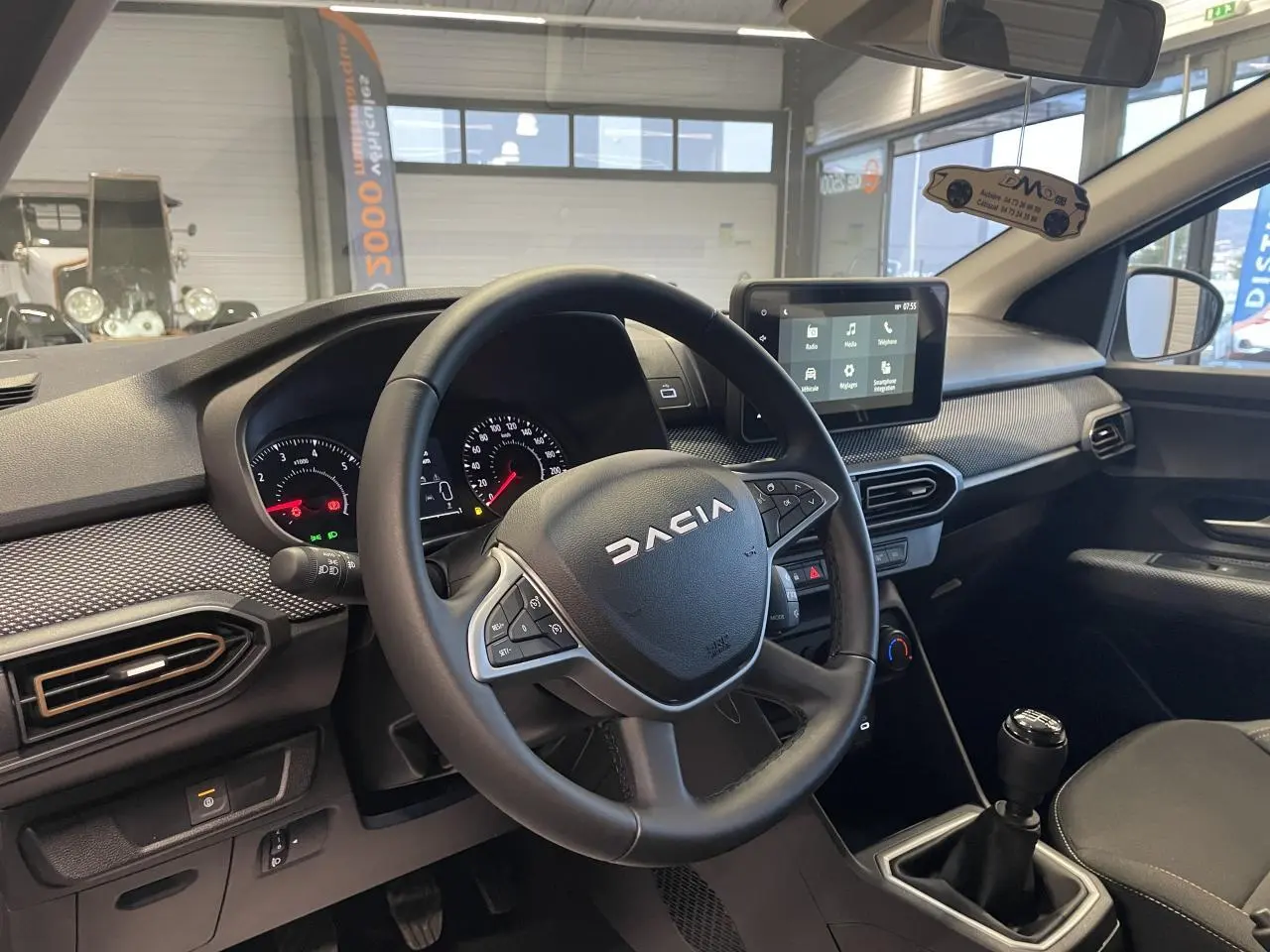 Vue intérieure côté conducteur du tableau de bord et volant noir de la Dacia Sandero TCe 90 Stepway 2025.