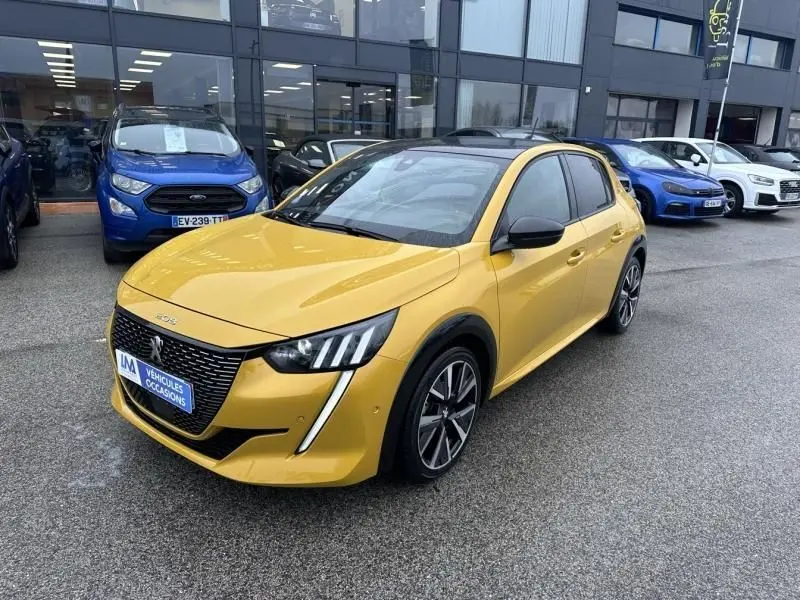 Peugeot 208 jaune vue 3/4 avant droit, avec toit noir et jantes alliage distinctives, stationnée devant un bâtiment.