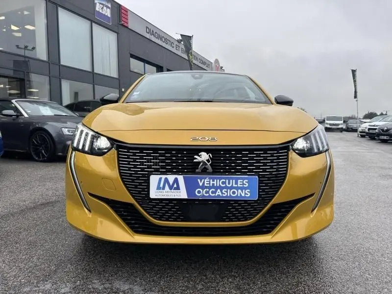Vue frontale d'une Peugeot 208 jaune 1.2 PureTech 130 GT 2021 avec calandre noire et phares LED distinctifs.