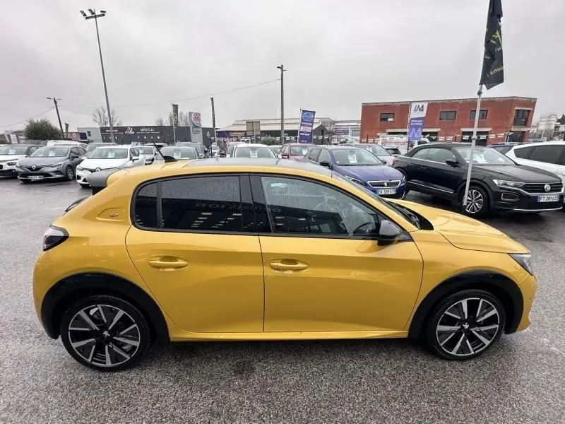 Vue latérale droite d'une Peugeot 208 jaune 1.2 PureTech 130 GT 2021 avec jantes alliage et vitres teintées.
