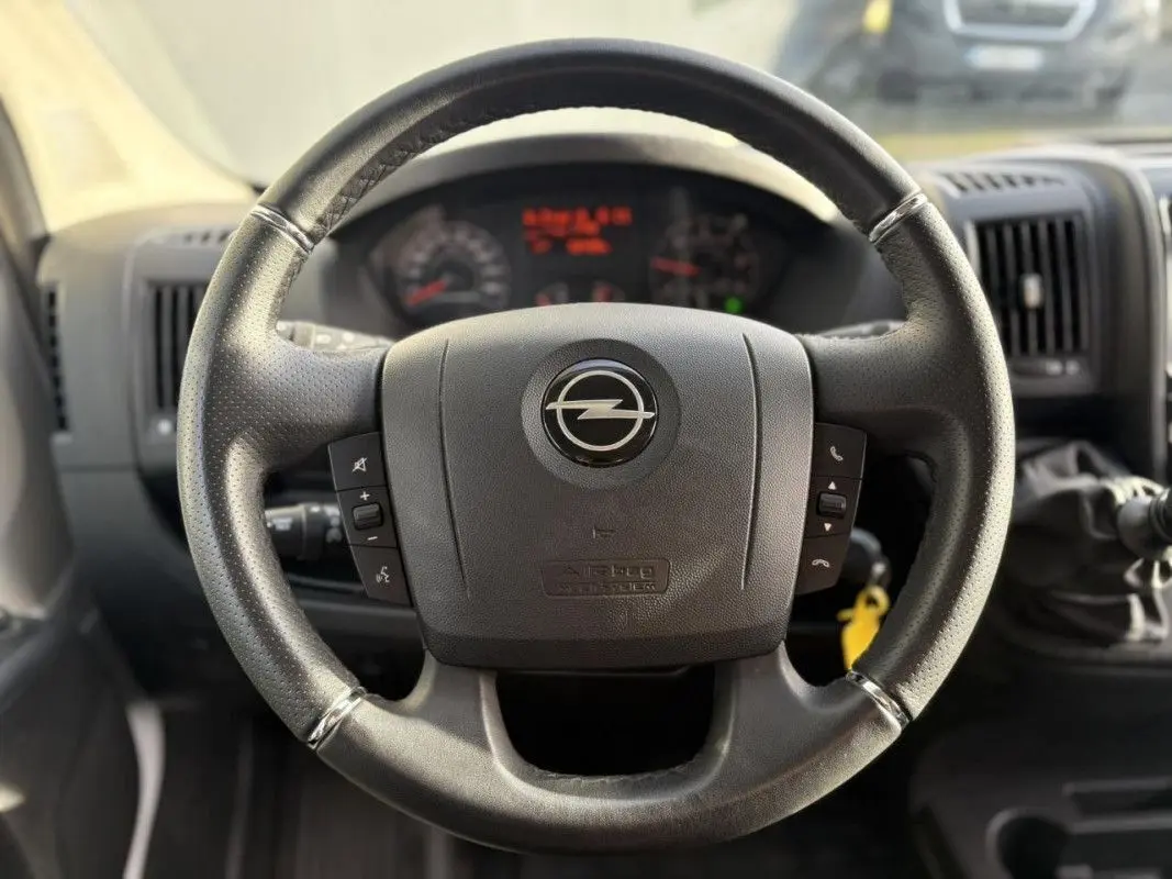 Volant noir de l'Opel Movano Fourgon 2.2 BlueHDi 140, vue frontale centrée sur les commandes au volant.