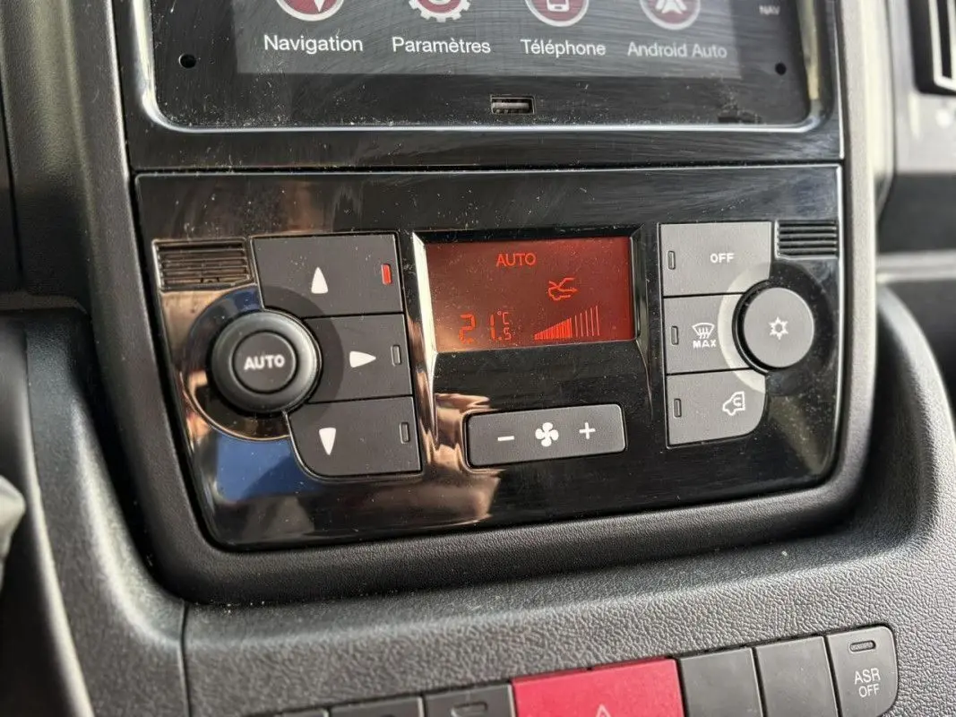 Gros plan sur la console centrale de l’Opel Movano Fourgon 2023, affichage digital rouge de la climatisation automatique.