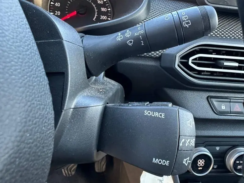 Gros plan sur la commande audio au volant côté gauche du tableau de bord du Dacia Jogger Vert Cèdre métallisé 2025.