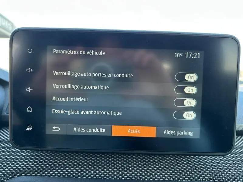 Écran tactile intérieur du tableau de bord du Dacia Jogger affichant les paramètres de verrouillage et d’essuie-glace.