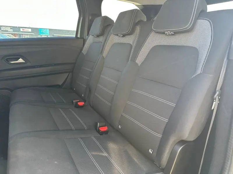 Vue latérale des sièges arrière noirs avec surpiqûres blanches du Dacia Jogger 7 places, finition Expression.