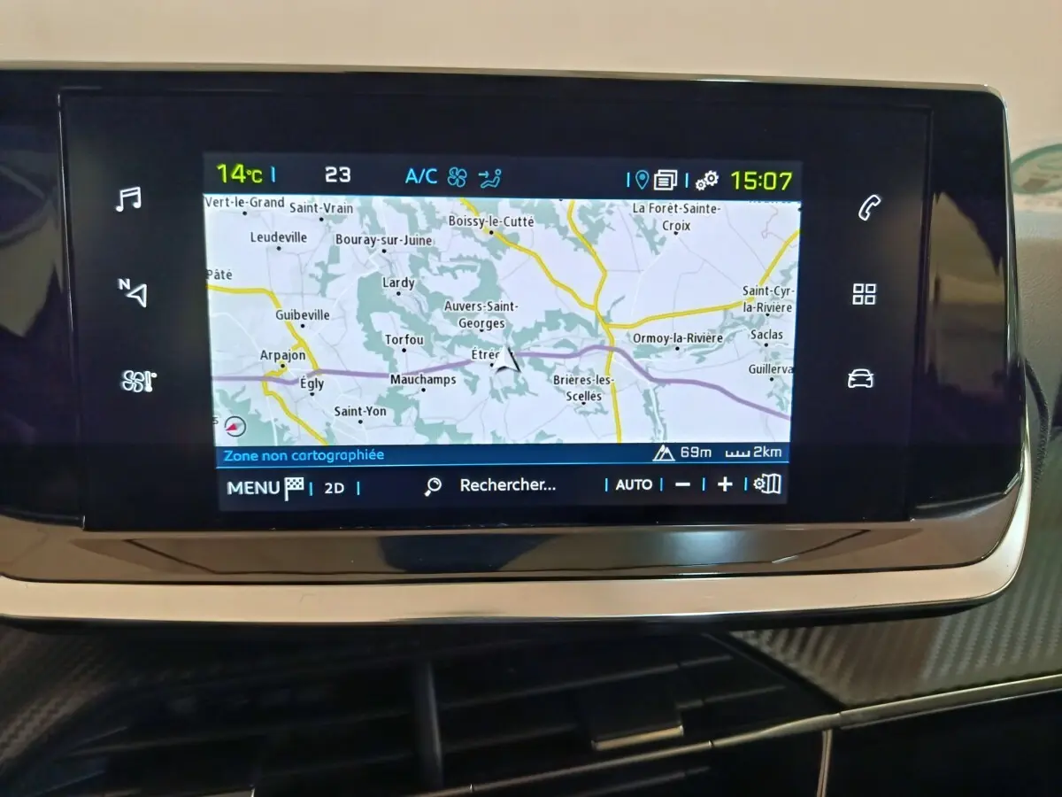 Écran tactile central du tableau de bord du Peugeot 208 électrique blanc, affichant la navigation GPS.