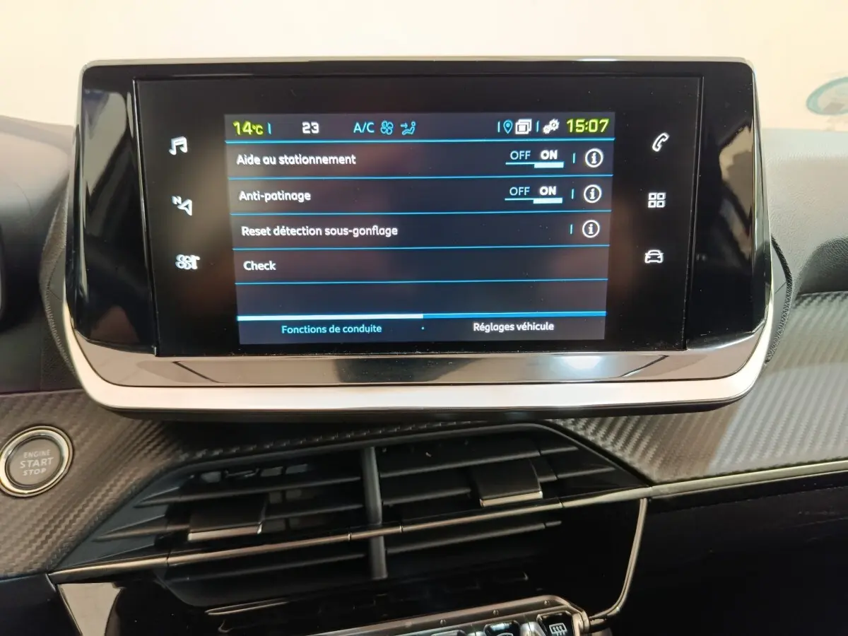 Écran tactile central affichant les réglages d’aide à la conduite dans l’habitacle d’une Peugeot 208 électrique blanche.