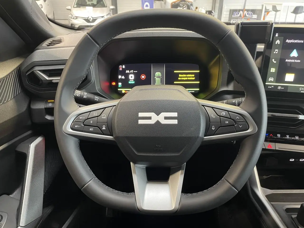Vue intérieure centrée sur le volant noir du Dacia Bigster 2026 avec combiné numérique et écran tactile à droite.