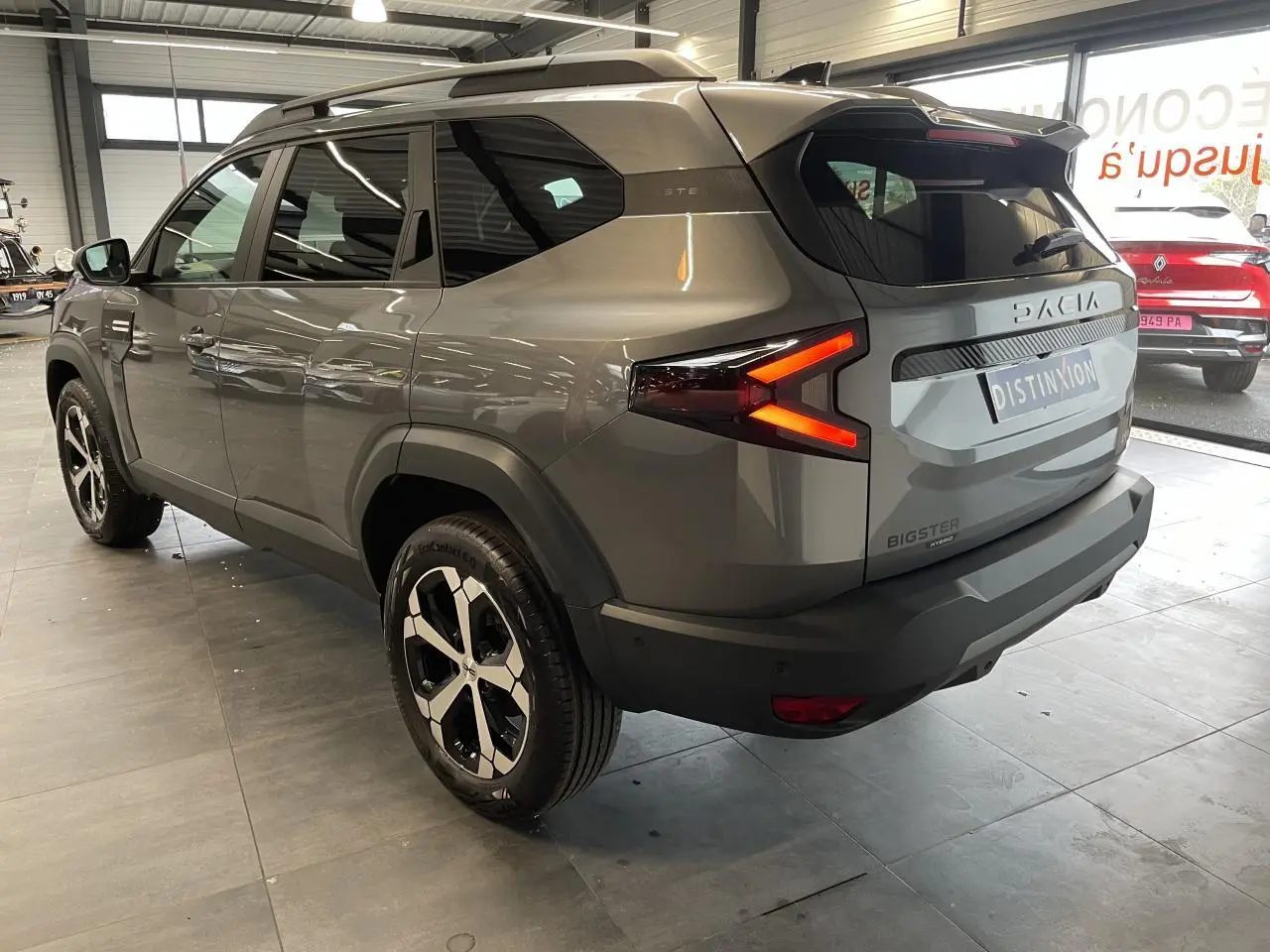 Vue 3/4 arrière droite du Dacia Bigster gris schiste avec feux arrière LED en forme de flèche et jantes alliage 18 pouces.
