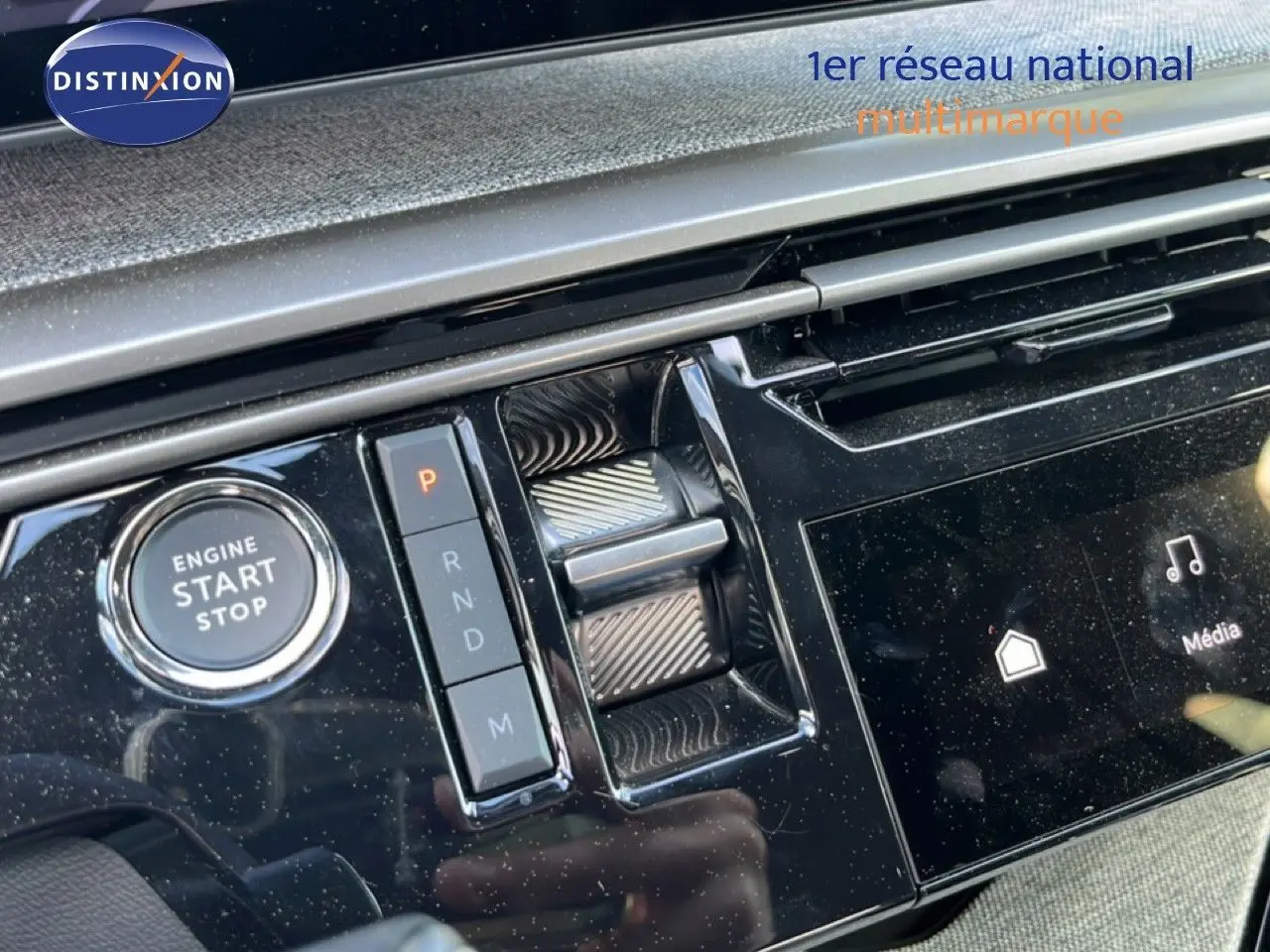 Détail de la console centrale noire brillante du Peugeot 5008 gris Artense, avec bouton start/stop et commande de boîte auto.