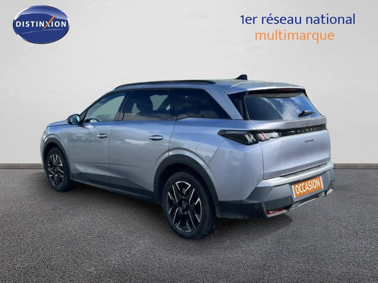 Peugeot 5008 Hybrid gris Artense métal, vue 3/4 arrière droit, jantes noires et toit panoramique visible.
