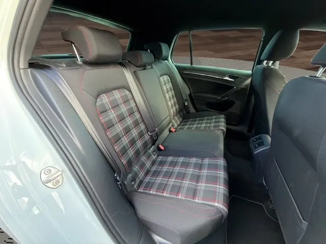 Vue arrière ouverte d'une Volkswagen Golf GTI Performance blanche de 2019, coffre spacieux visible avec banquette rabattable.