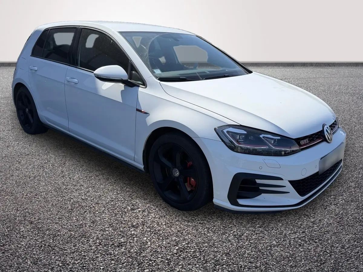 Vue arrière d’une Volkswagen Golf GTI Performance blanche, avec double sortie d’échappement et toit noir contrasté.