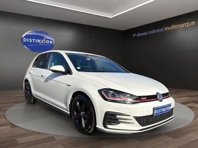 Vue frontale d'une Volkswagen Golf GTI Performance blanche, avec calandre noire et détails rouges distinctifs.