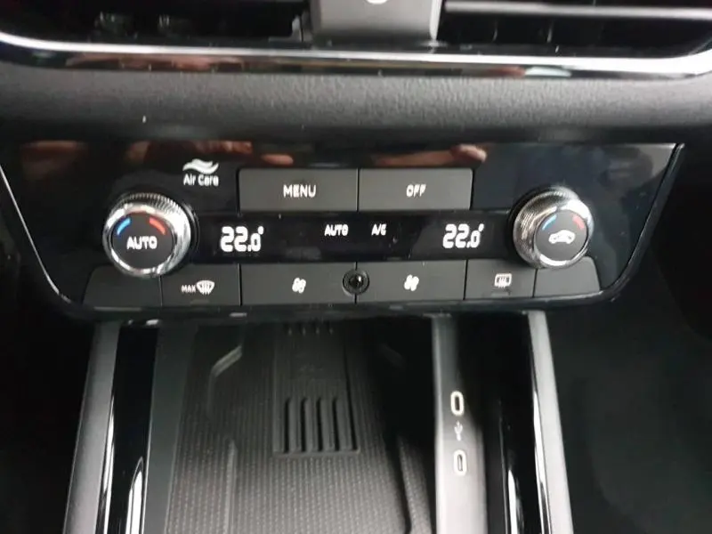 Détail de la console centrale avec commandes de climatisation bi-zone et finition noire brillante dans un Skoda Kamiq gris diamant.