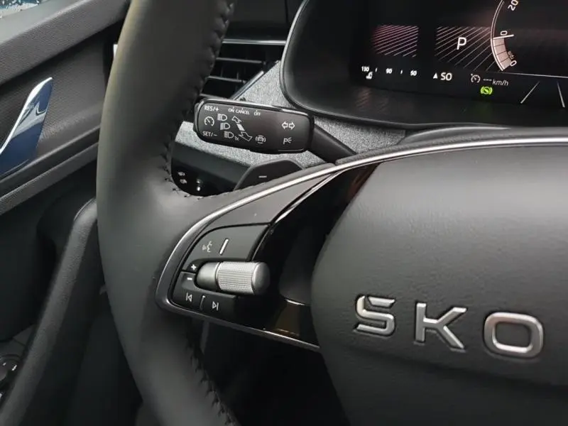Gros plan sur le volant cuir multifonction et la commande de régulateur de vitesse du Skoda Kamiq 2025, intérieur noir.