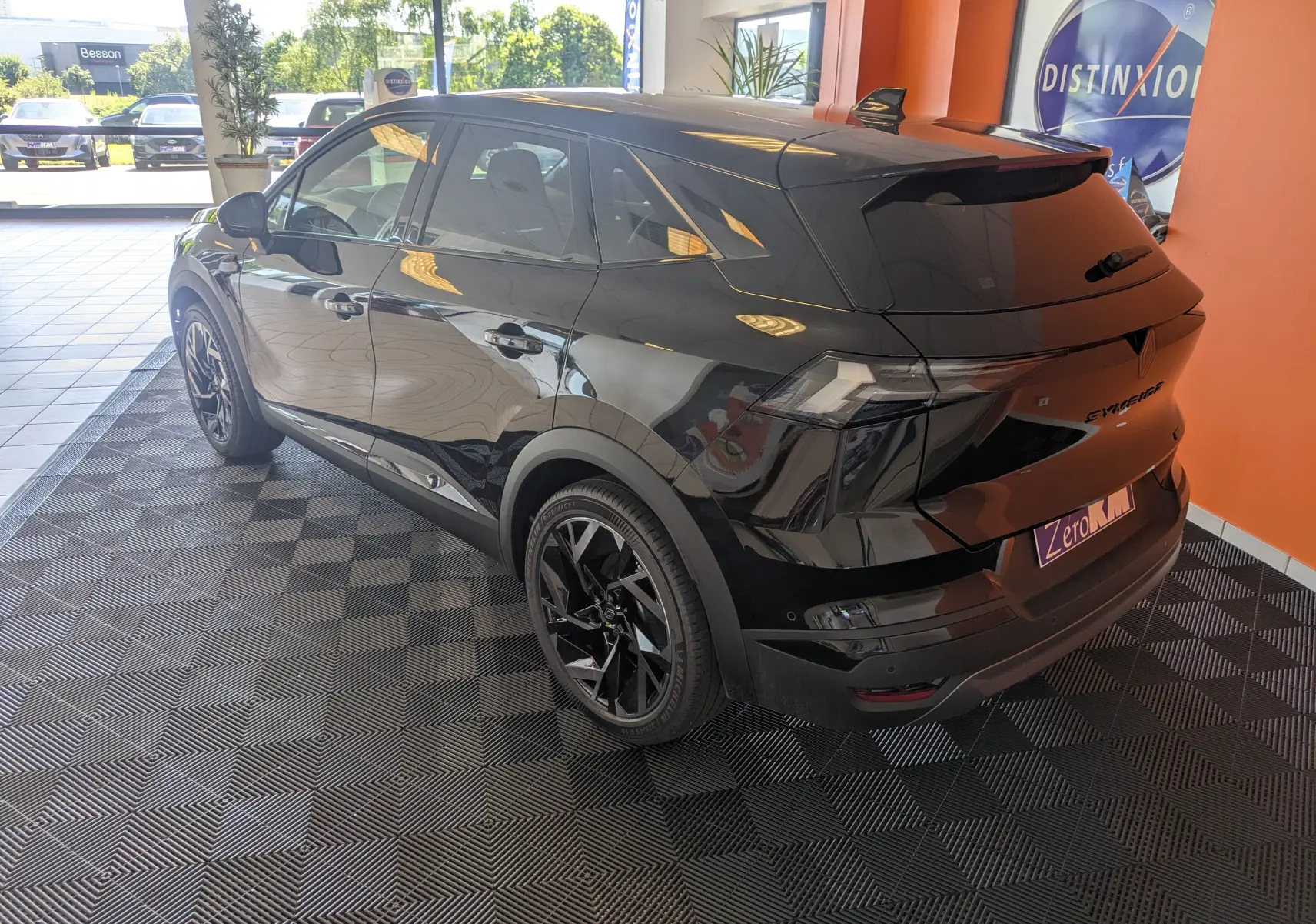 Vue 3/4 arrière droite du Renault SYMBIOZ noir étoilé avec jantes alliage 19'' Elixir dans un showroom.