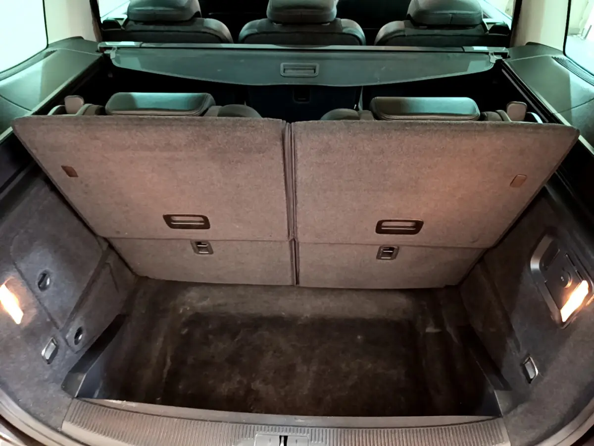 Coffre ouvert du Volkswagen Sharan marron 2017, montrant la 3ème rangée de sièges rabattue et l'espace de chargement.