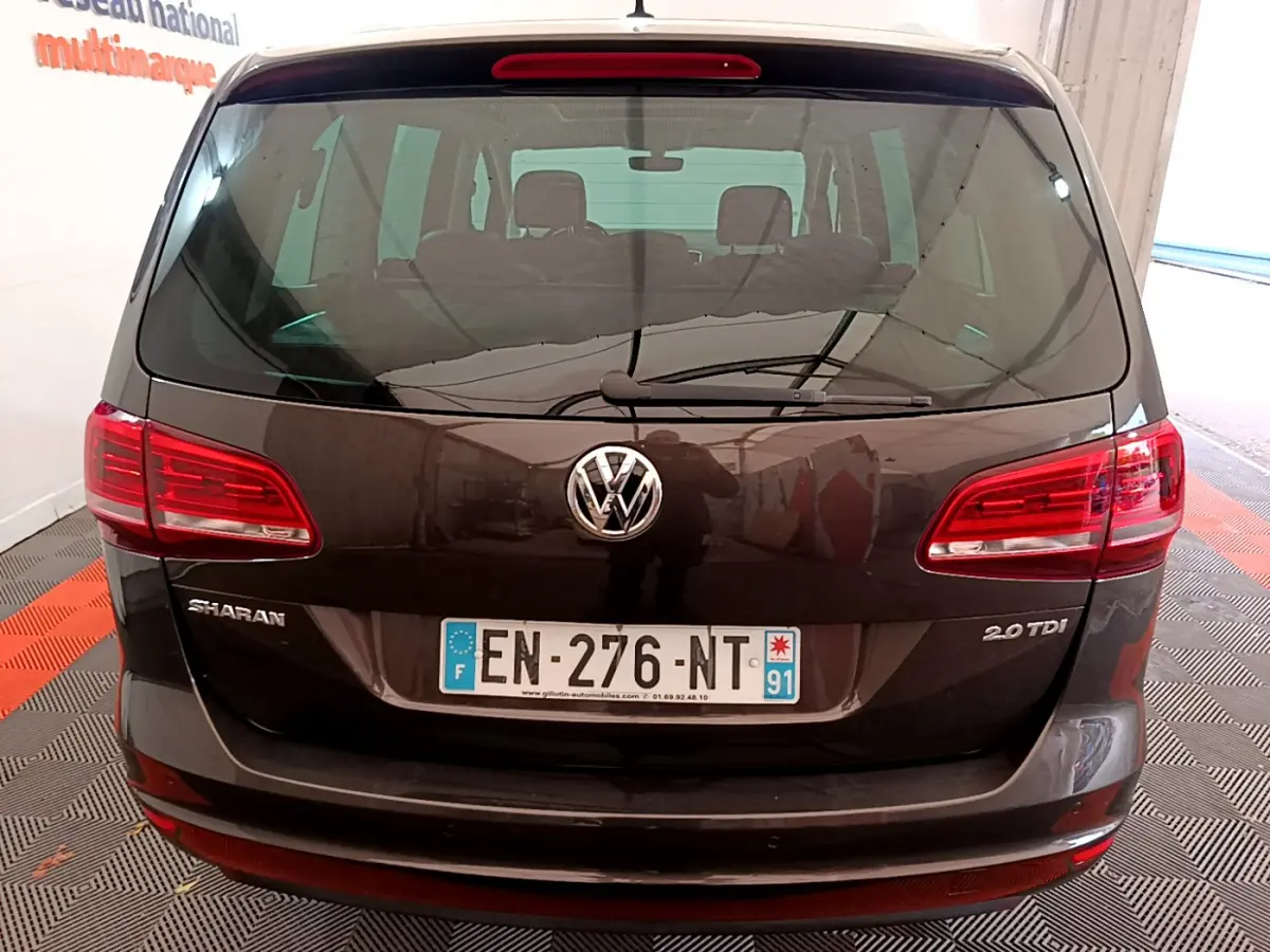 Vue arrière d'un Volkswagen Sharan marron 2.0 TDI avec feux rouges et logo VW bien visibles.