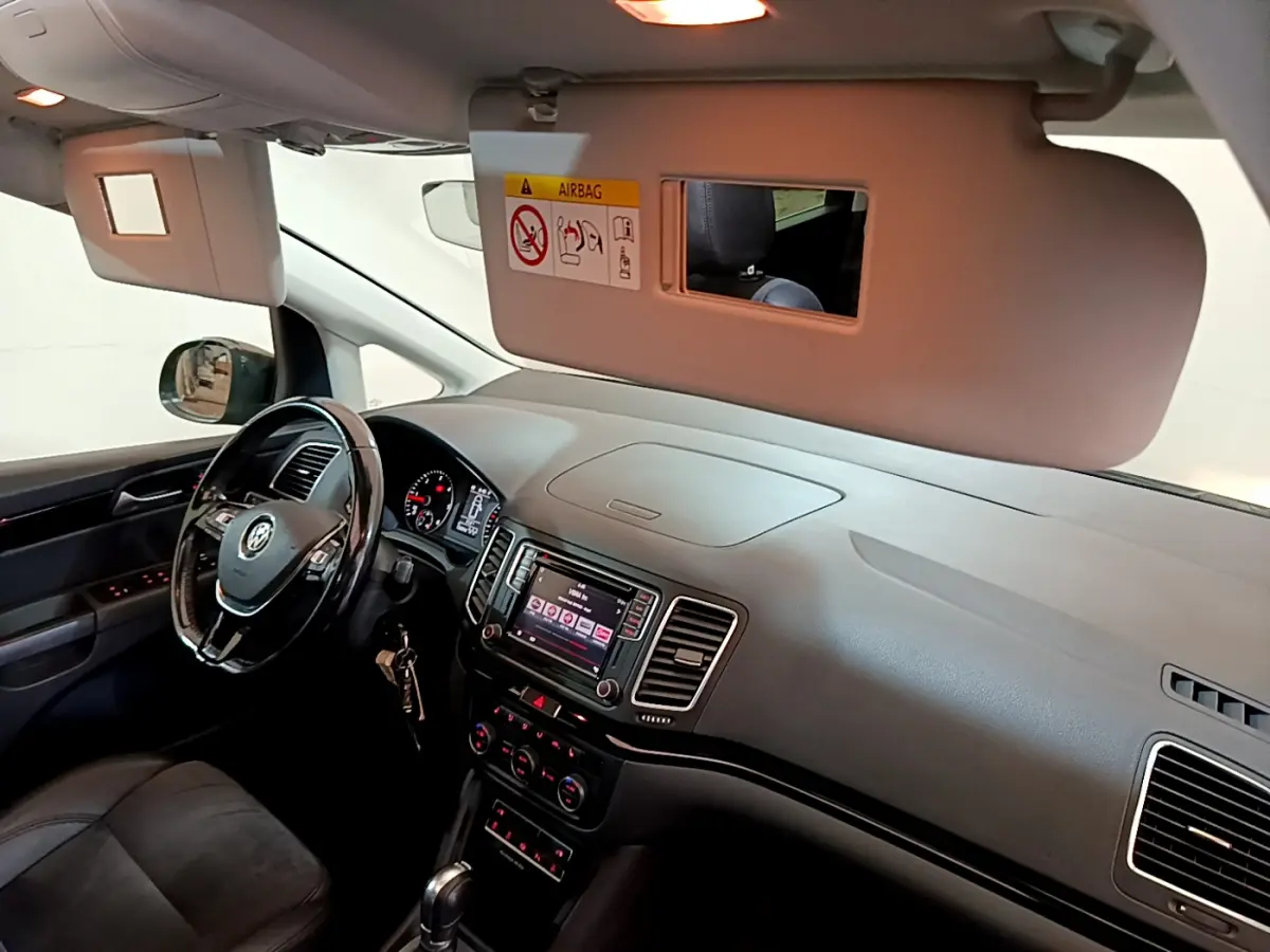 Intérieur avant du Volkswagen Sharan marron 2017, tableau de bord et volant cuir avec écran tactile central visible.