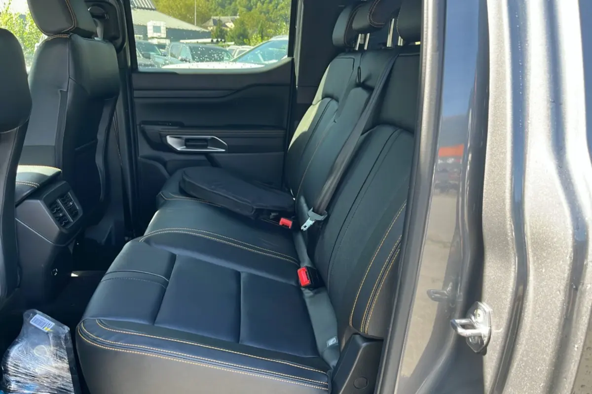 Vue intérieure côté droit des sièges arrière en cuir noir avec surpiqûres jaunes du Ford Ranger gris carbone 2025 Wildtrak Plus.