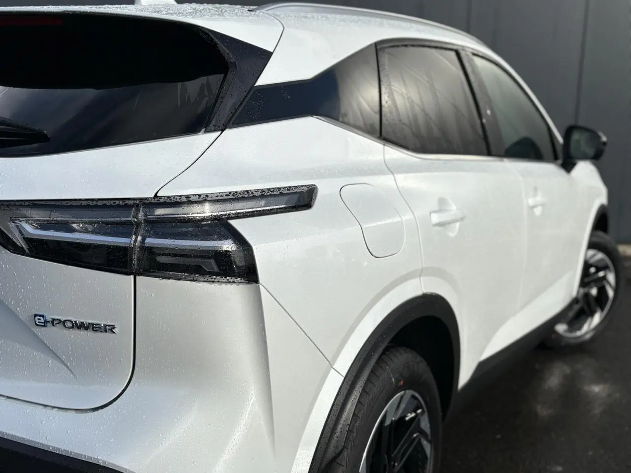 Vue 3/4 arrière droite du Nissan Qashqai blanc nacré avec badges e-POWER et jantes alliage 18 pouces.