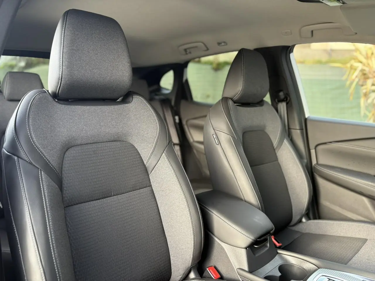 Vue intérieure rapprochée des sièges avant en tissu gris et noir du Nissan Qashqai III e-Power 2025.