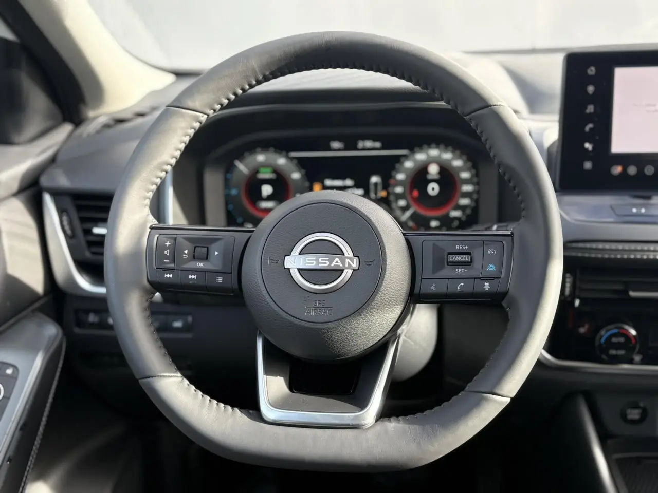 Vue frontale du volant cuir noir du Nissan Qashqai III e-Power 2025 avec commandes intégrées et tableau de bord numérique.