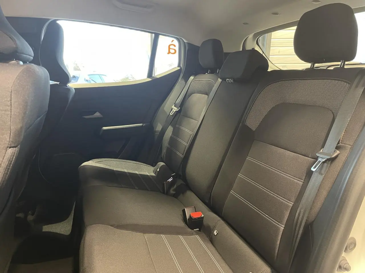Vue intérieure côté droit des sièges arrière noirs du Dacia Sandero Stepway Expression 2025 blanc glacier.