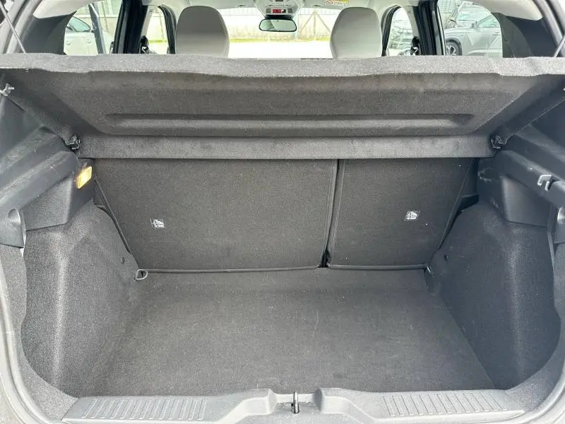 Coffre ouvert vu de l'arrière d'une Citroën C3 1.2 Turbo 100ch MAX gris Mercury, intérieur noir et banquette rabattue.