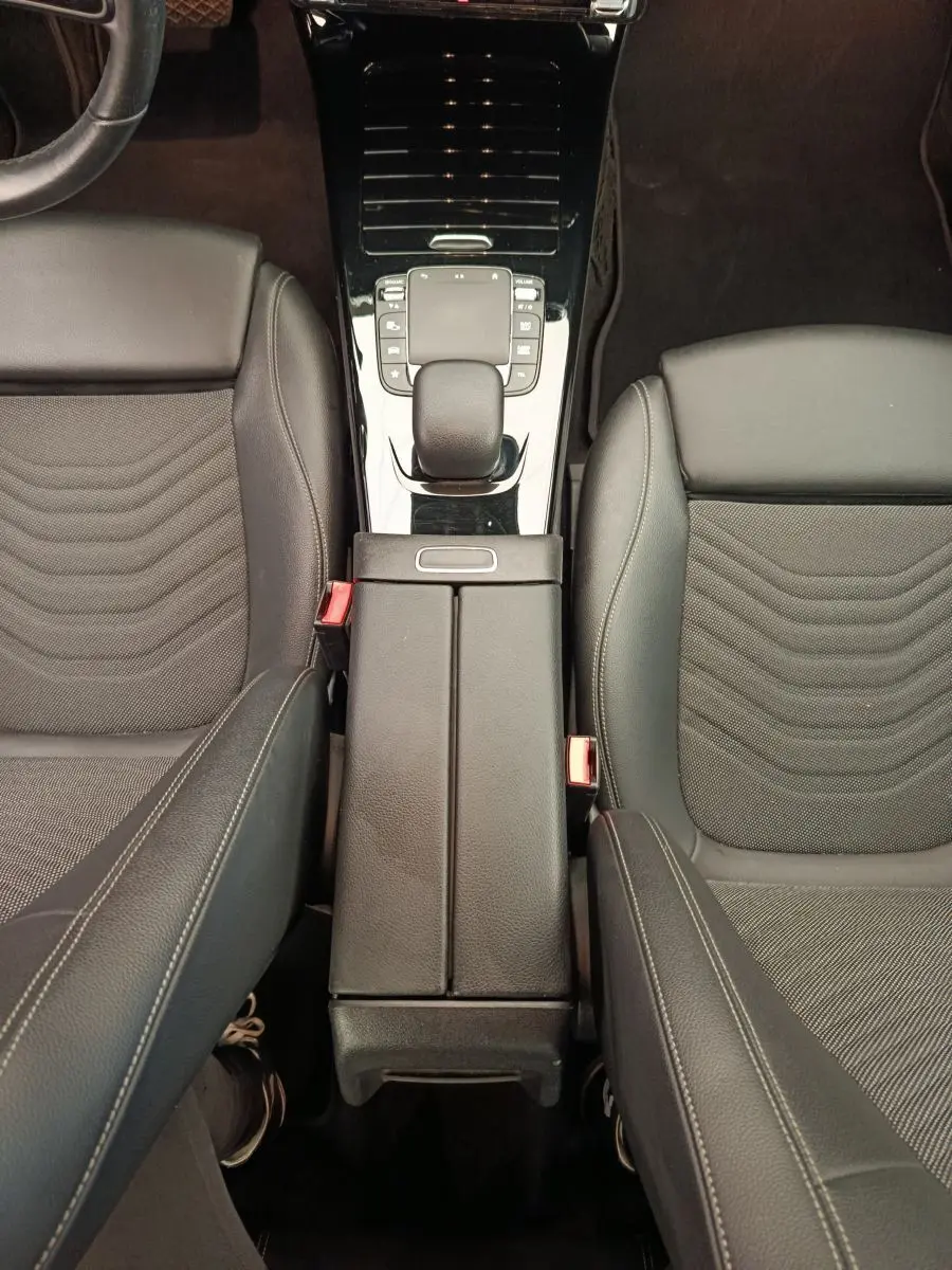 Vue plongeante sur la console centrale et les sièges avant en cuir noir de la Mercedes Classe A A 180 Business Line 2020.