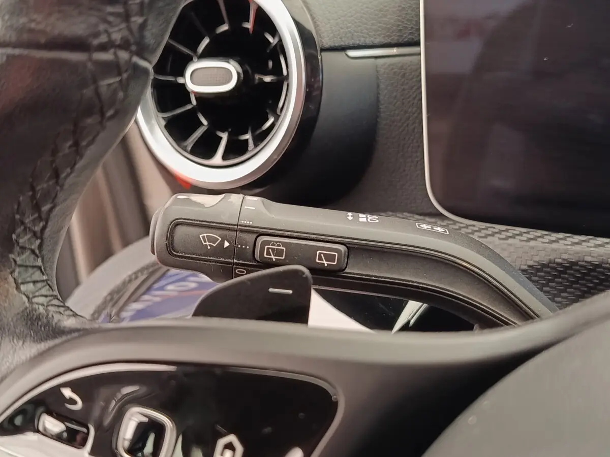 Gros plan sur la commande d’essuie-glace et le volant cuir noir d’une Mercedes Classe A 180 Business Line 2020.