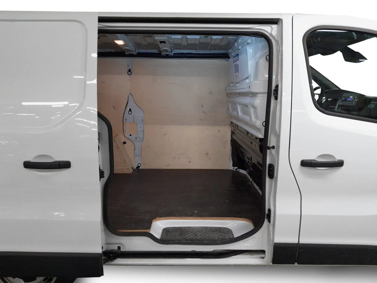 Vue latérale gauche du Renault Trafic Fourgon blanc minéral 2024 avec porte coulissante ouverte sur l’espace de chargement vide.
