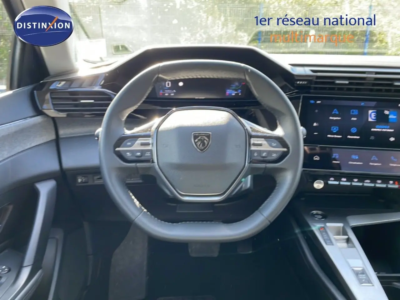 Vue intérieure centrée sur le volant cuir noir et le tableau de bord digital de la Peugeot 308 SW 2025 gris Artense.