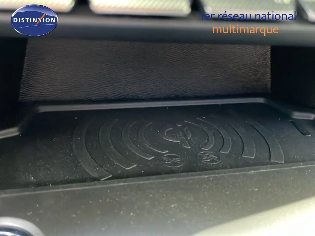 Détail du chargeur sans fil dans l’habitacle d’une Peugeot 308 SW gris Artense 2025.